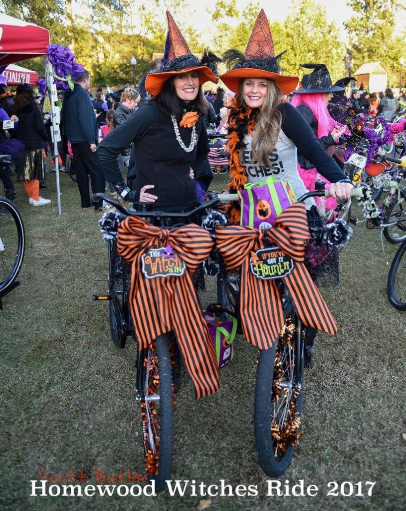 2 women dressed like witches wtih decorated bikes